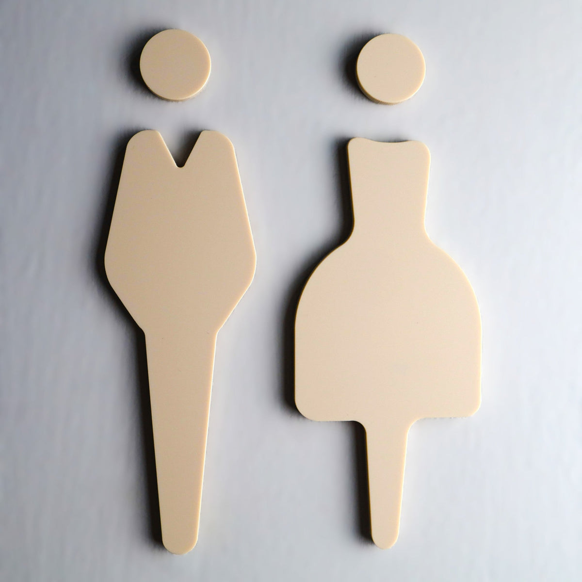 Beige stone-effect acrylic restroom sign with simple symbols