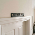 Black acrylic Choose Joy door topper sign above interior doorway