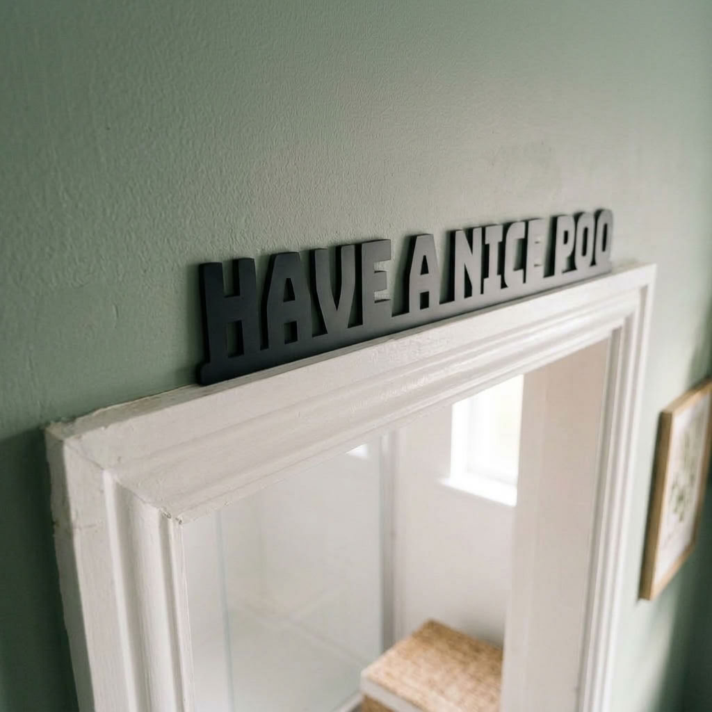 Modern funny bathroom decor sign above white door frame