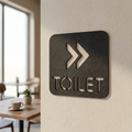 Black toilet direction sign with right arrows for offices, cafés, restaurants and commercial businesses